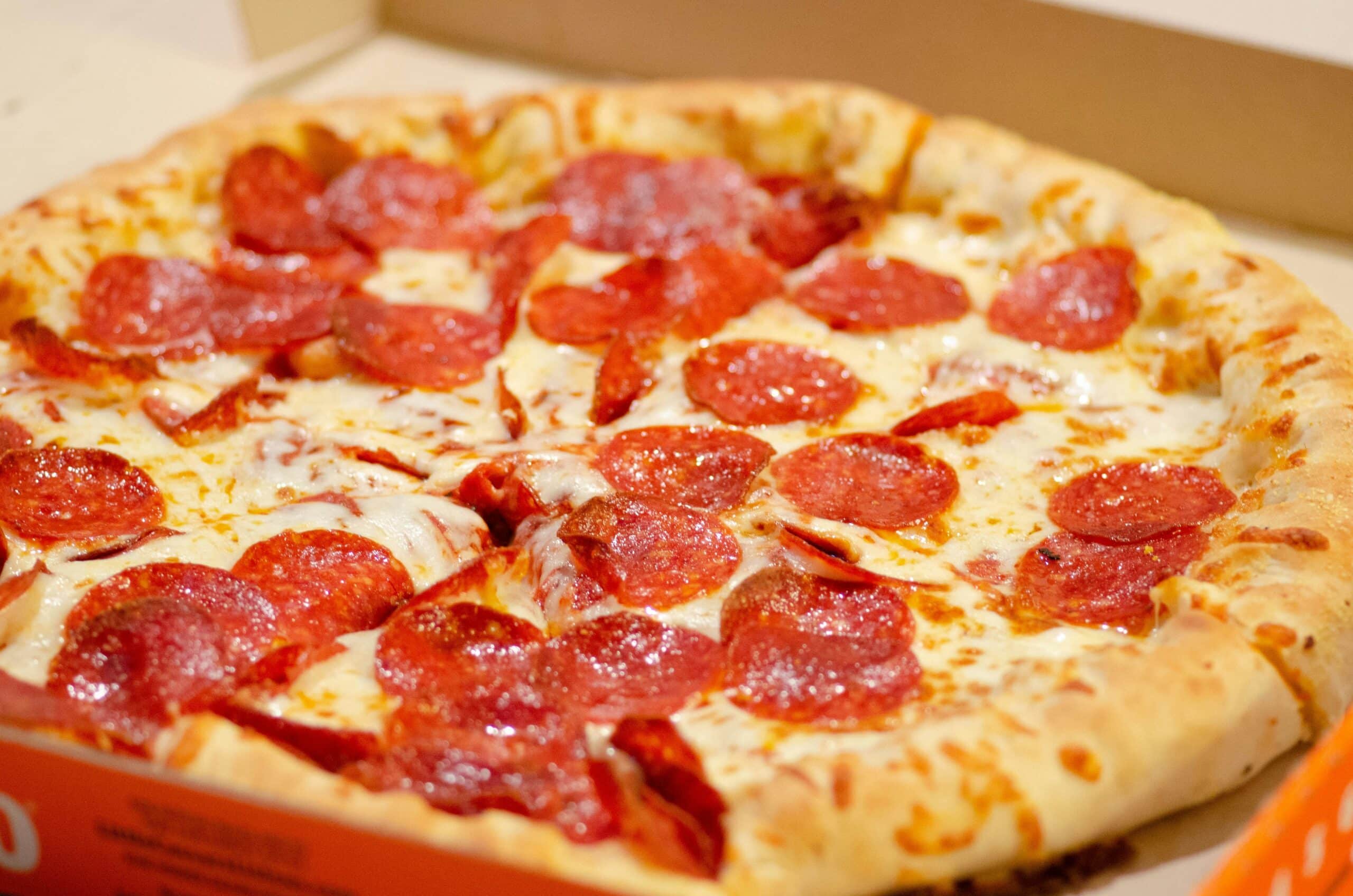 En nybakt pepperonipizza i en pappeske, klar til servering.
