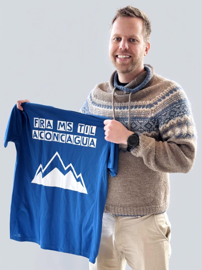 Sondre Holm poserer med t-skjorten med påskriften fra MS til Aconcagua
