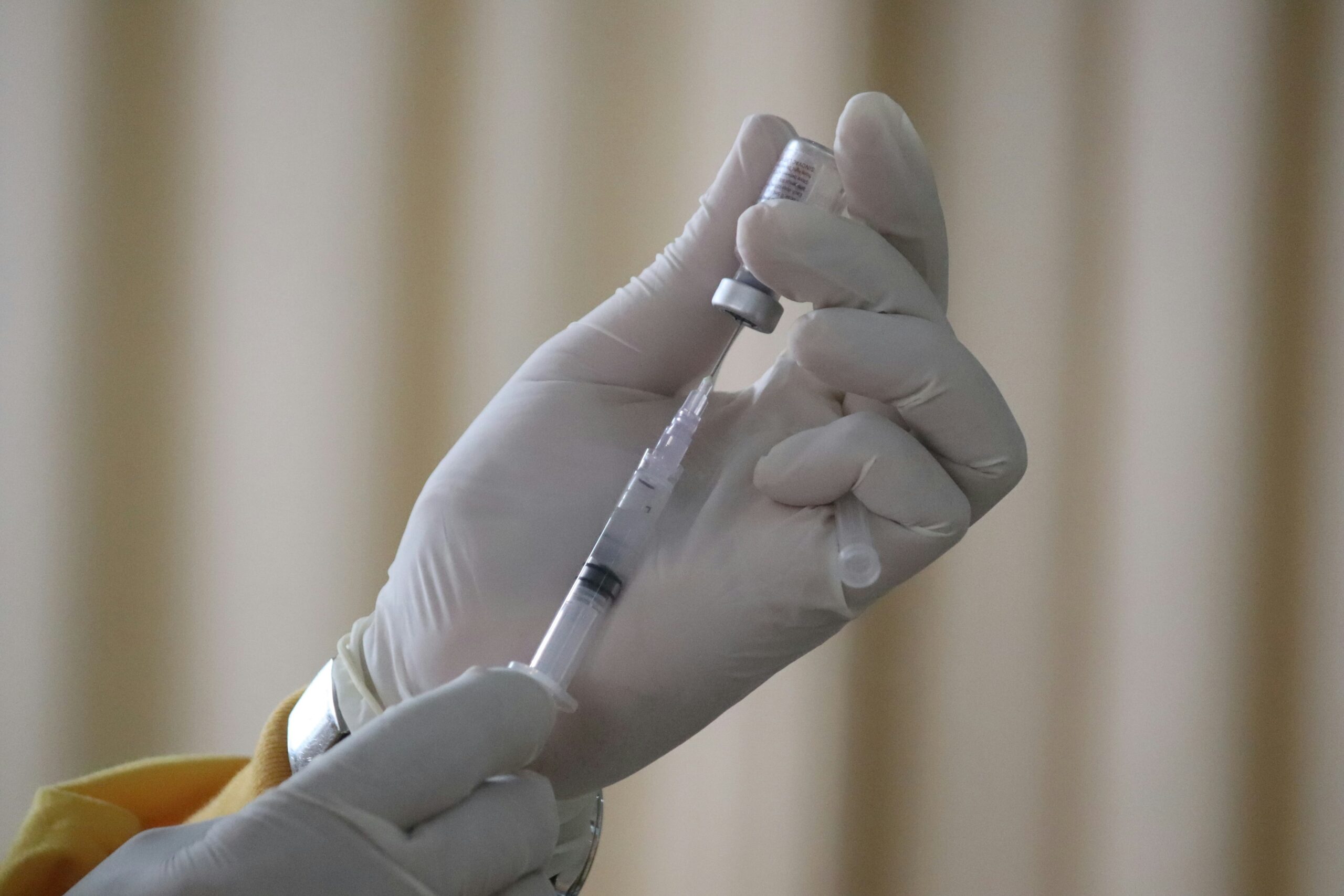 Nærbilde av en hånd som fyller opp en sprøyte. Kan illustrere medisiner som natalizumab