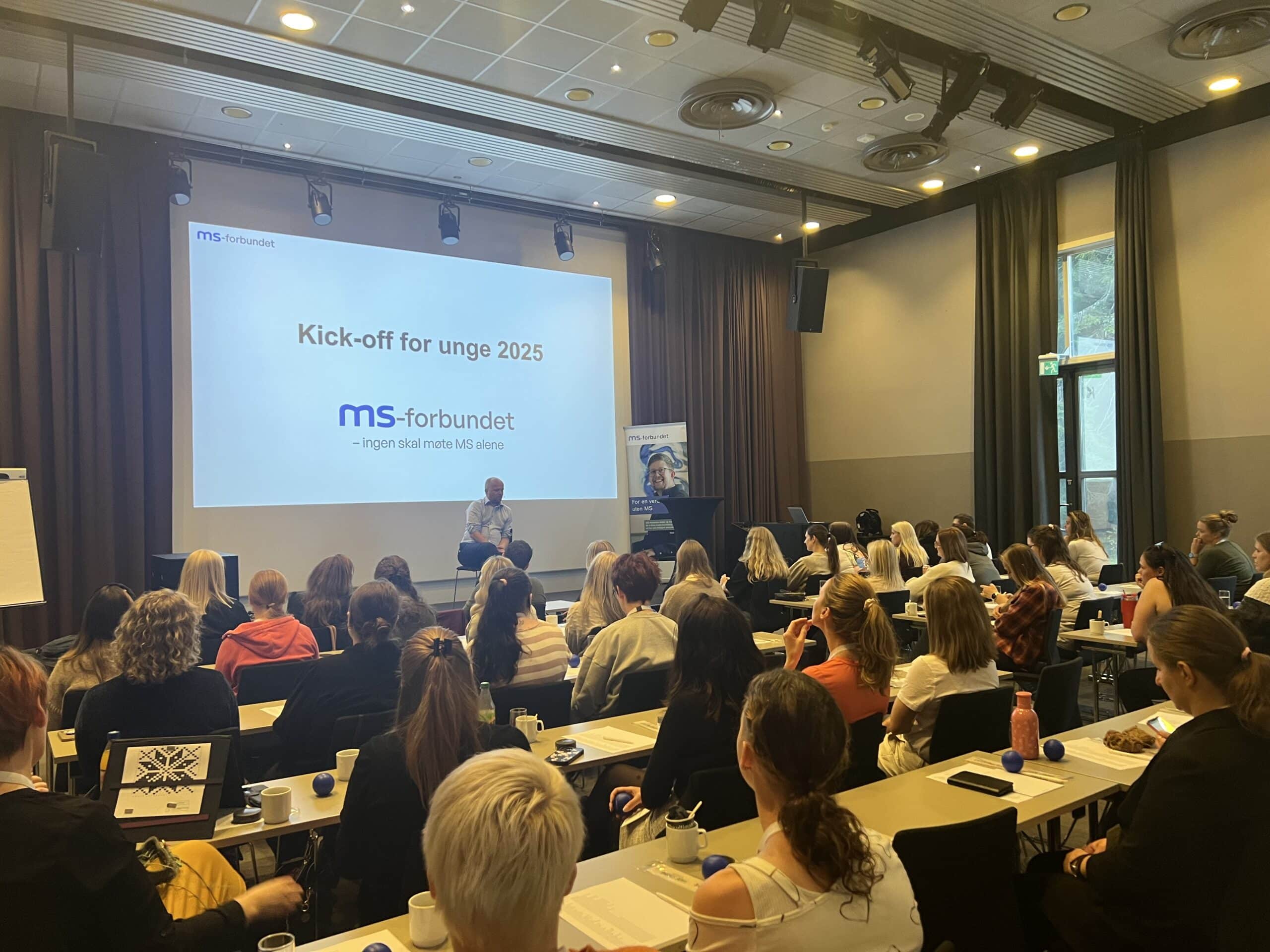 Trgve Slagsvold Vedum åpnet kick-off for unge i 2025. Her oppe på scenen med ryggen til publikummere i forkant.