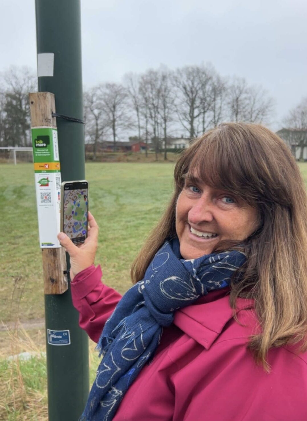 Bilde av Evy Martinsen, likeperson i MS-forbundet. Hun står foran en stolpe i forbindelse med stolpejakt.